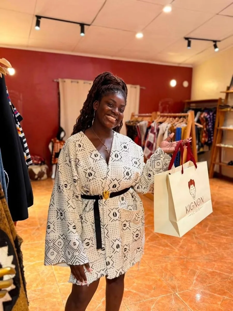 Une cliente en kimono ceinturé, sac Kignon à la main, dans la boutique