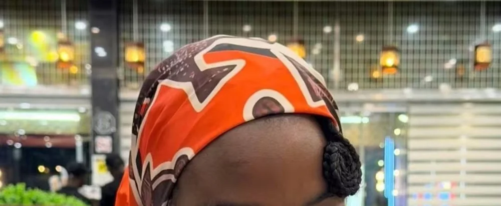 Carré de soie orange et marron, noué en foulard