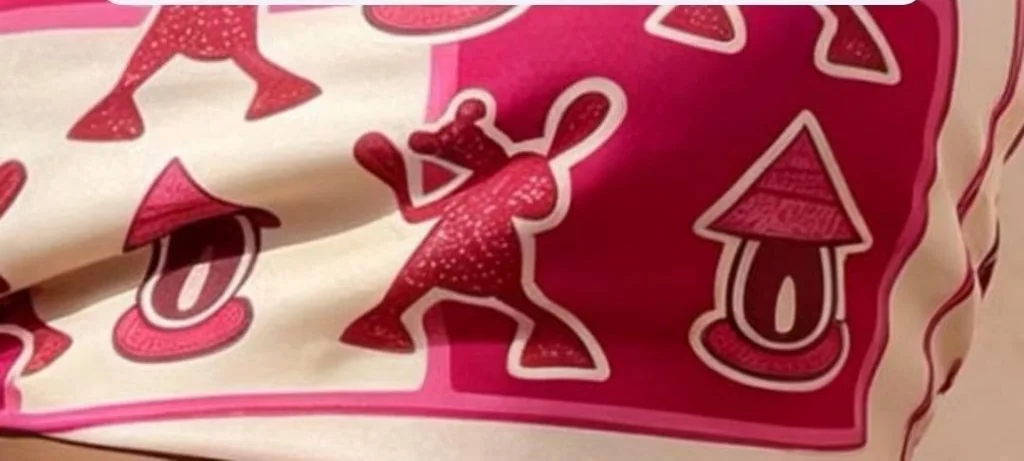 Carré de soie rose aux personnages fuchsia, noué au cou